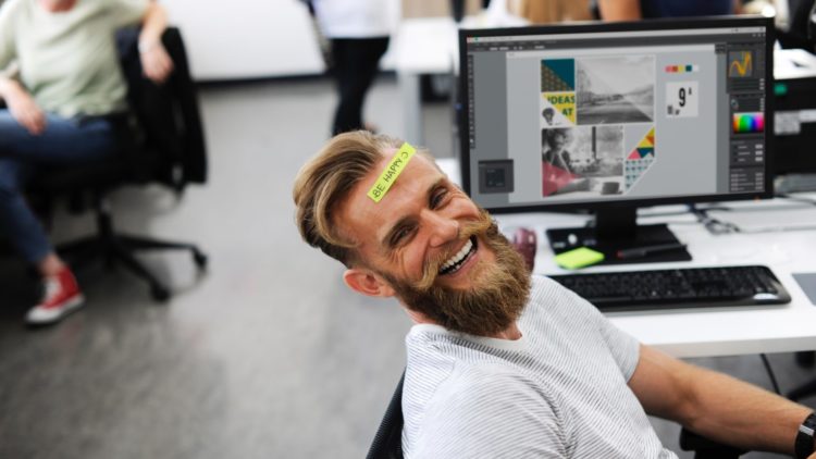 man at desktop computer smiling